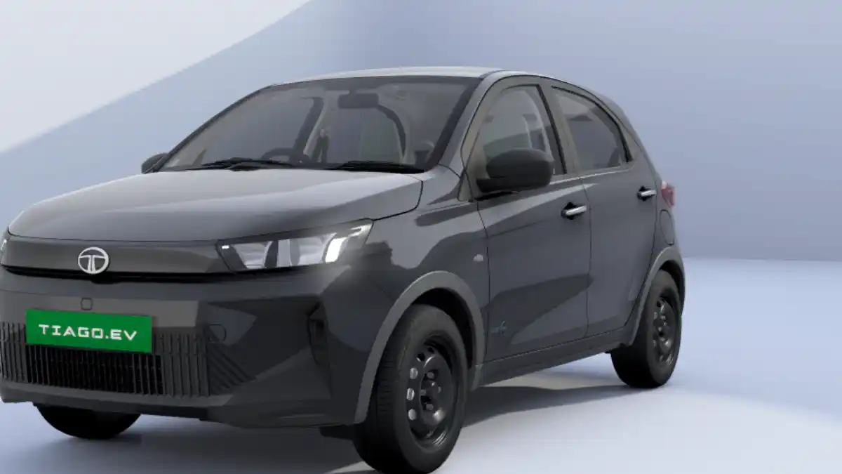Tiago EV Mileage: 5 बड़े सच जो कंपनी छुपाती है, जानिए असली हाईवे और सिटी की रेंज का गणित Side view of Teal Blue Tata Tiago EV parked at a public charging station in India, showcasing electric car real-world range test.